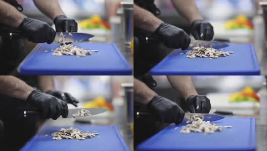 Young chef cutting mushrooms in restaurant kitchen高清在线视频素材下载