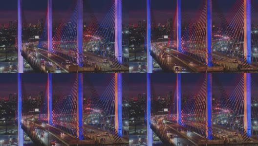 夜深时分，科修斯科大桥上的车流不断变换着颜色，背景是曼哈顿和布鲁克林的远处景色。航拍视频与静态摄像机运动。高清在线视频素材下载