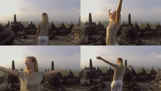 旅游女孩在婆罗浮屠寺拥抱日出的慢动作视频，印度尼西亚。People discovery Asia概念高清在线视频素材下载