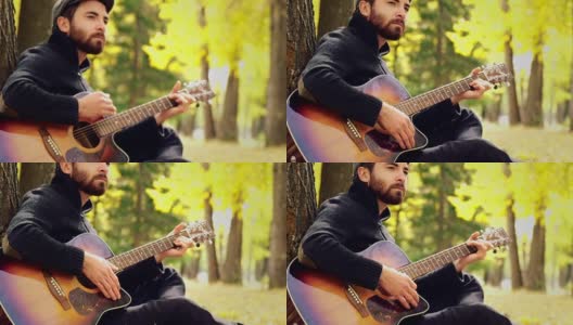 一个男人在树林里弹原声吉他高清在线视频素材下载