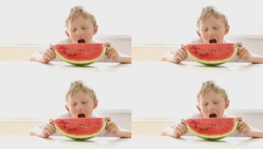 金发小男孩喜欢吃一大块西瓜高清在线视频素材下载