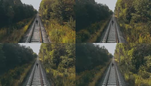 在秋天森林铁路上奔跑的人。无人机的后视图。运动员在道路上清晰的视野地平线。电影的拍摄高清在线视频素材下载