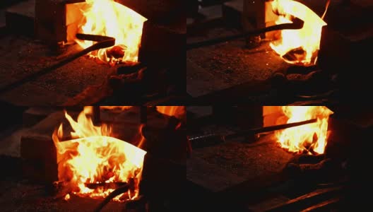 一个铁匠扇火焰的特写镜头，使用工具防止灰烬，火花飞溅到一边的慢动作。铁匠的手的特写高清在线视频素材下载