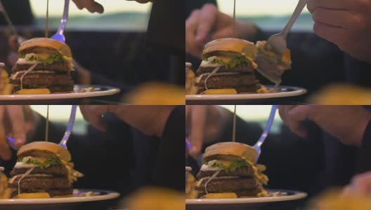 男人切着汉堡吃，快餐和肥胖，特写高清在线视频素材下载
