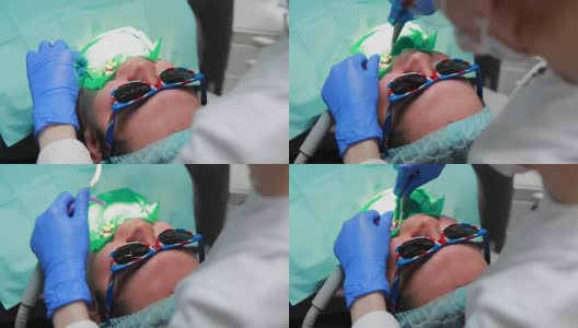 牙医和护士正在给一个病人补牙。用bormashenko钻牙，清除蛀牙和密封高清在线视频素材下载
