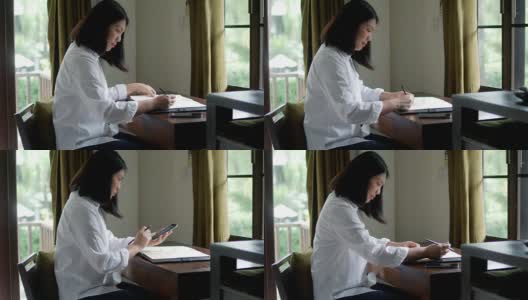 在家里工作的女人在纸上记笔记高清在线视频素材下载