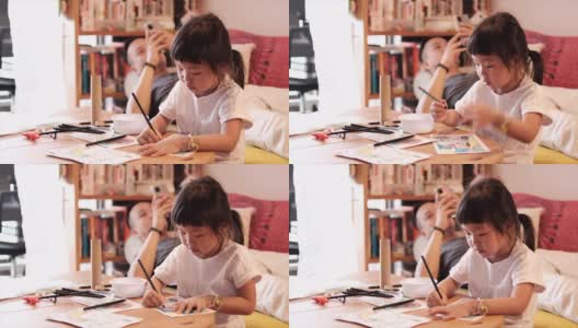 一个亚洲女孩和父亲在家画画高清在线视频素材下载
