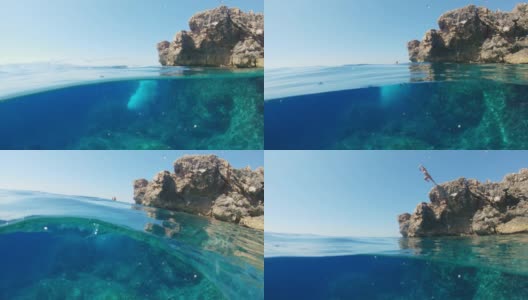 克罗地亚亚得里亚海，一名身穿比基尼的年轻女子从岩石上跳入阳光灿烂的海洋高清在线视频素材下载