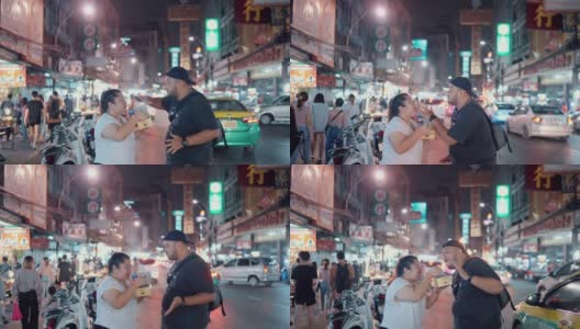 一对甜蜜的情侣在曼谷Yaowarat路享受街边小吃高清在线视频素材下载