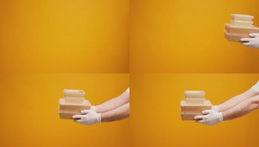 在黄色的演播室背景下，人们的手互相擦过装有食物的盒子高清在线视频素材下载