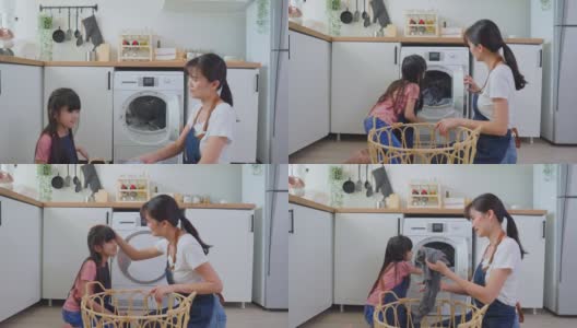 亚喜一家人待在家里，妈妈教女儿洗脏衣服。年幼可爱的小女孩帮助父母妈妈把衣服放在家里的洗衣机里。Domestic-Housekeeping。高清在线视频素材下载