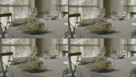 在白色桌布上的桌子上有餐具和一个玻璃杯。盘子已经洗干净，可以上菜了高清在线视频素材下载