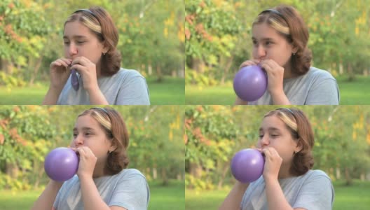 一个染了头发的少女在绿色大自然的背景下吹气球高清在线视频素材下载