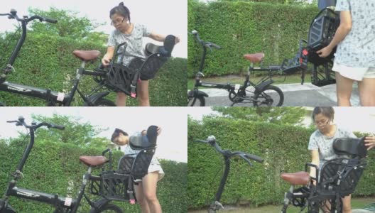 妇女安装自行车后儿童座位的自行车在前院的家高清在线视频素材下载