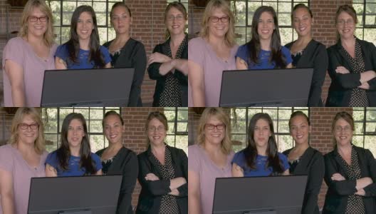 四个自信成功的商业女性微笑在电脑显示器后面高清在线视频素材下载
