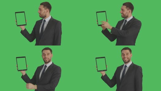 中景一个英俊的商人拿着平板电脑与另一只手做滑动触摸手势。平板电脑和背景都是绿屏。高清在线视频素材下载