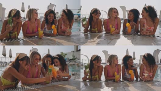 一群欢快的女性朋友在游泳池里一边喝着鸡尾酒一边放松高清在线视频素材下载