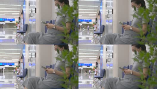 快乐的孕妇在机场用手机高清在线视频素材下载
