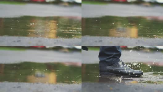 穿着黑鞋的男人慢镜头踩进水坑里高清在线视频素材下载
