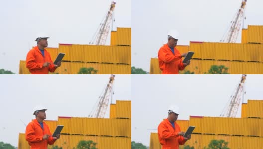 工程师使用数字平板电脑在港口的集装箱背景高清在线视频素材下载