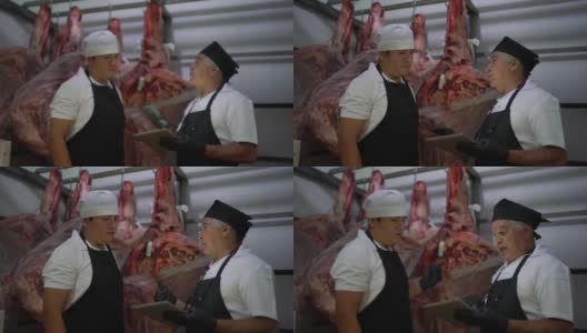 肉贩在肉柜中使用数字平板分析产品高清在线视频素材下载