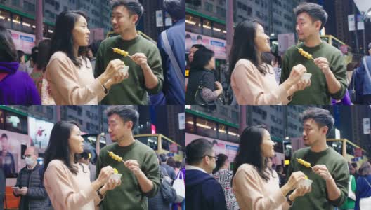 SLO MO:一对年轻夫妇吃街头小吃的中景高清在线视频素材下载