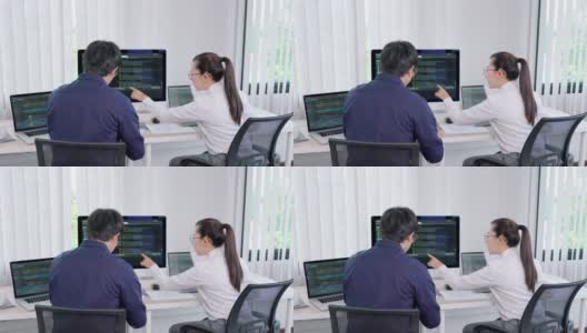 两个专业的IT程序员讨论和工作在电脑上编码开发网站设计和开发技术的4k视频片段高清在线视频素材下载
