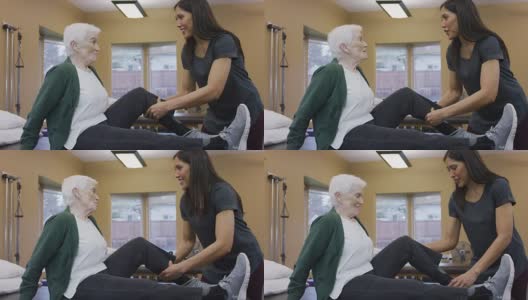 理疗师按摩老年女性的小腿肌肉高清在线视频素材下载