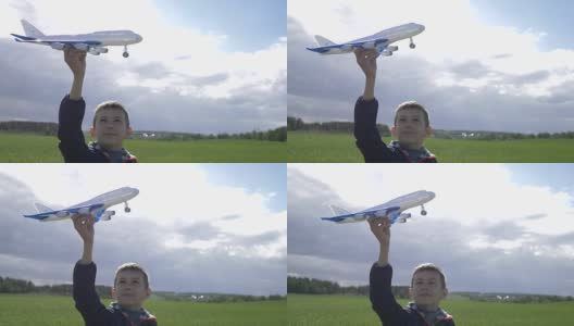 快乐的男孩梦想家手里拿着一架飞机，看着他高清在线视频素材下载