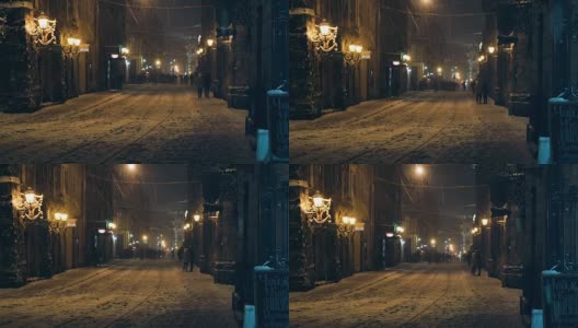 白雪覆盖的夜晚街道在老城利沃夫，乌克兰。老城的夜晚街道，正在下雪。高清在线视频素材下载