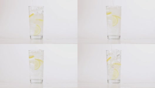 玻璃杯中的水与柠檬和冰隔离在白色的背景高清在线视频素材下载