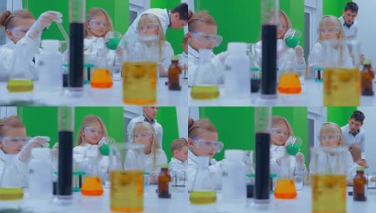 孩子们在学校的实验室里学习化学。一组孩子在化学课上做实验高清在线视频素材下载