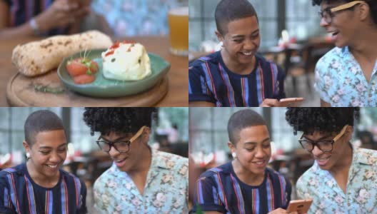 快乐的朋友在餐厅边吃着Burrata奶酪边玩手机高清在线视频素材下载