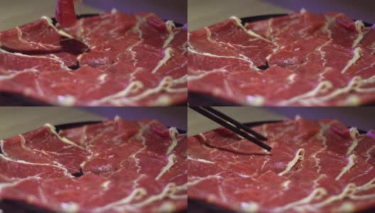 用筷子夹住牛肉生肉的慢动作。北京的中国火锅高清在线视频素材下载