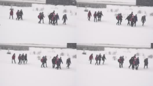 孩子们从学校走在雪上，背景。慢镜头,模糊的高清在线视频素材下载