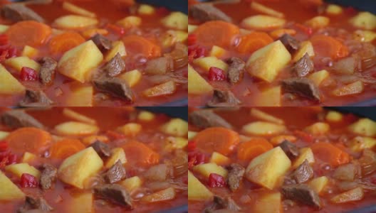 在红锅里炖土豆和红萝卜，煮开后咯咯地笑。高清在线视频素材下载