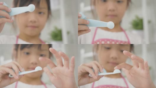 亚洲女孩在家里烘烤前用量匙准备盐。高清在线视频素材下载