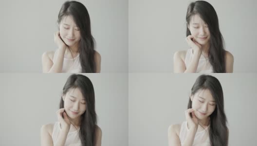 黑色长发的韩国美女在白色摄影棚里拍照。风吹过她的头发。慢动作视频高清在线视频素材下载