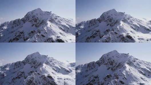 空中飞行向后移动，越过雪峰山脊建立。冬季户外雪高山野自然景观。4k无人机飞行建立镜头高清在线视频素材下载