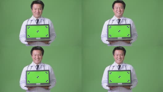 成熟的日本男人医生反对绿色背景高清在线视频素材下载