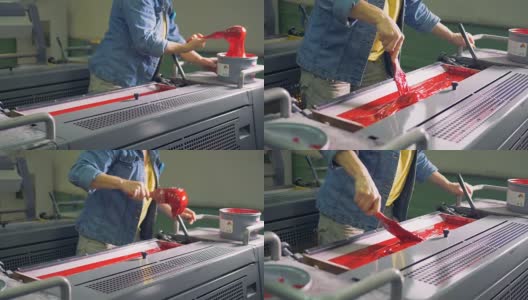 一个人从一个罐子里拿出颜料，把它放进印刷机。高清在线视频素材下载