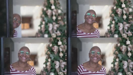 快乐老女人开门，圣诞树在背后高清在线视频素材下载