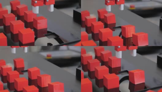 在机器人展上挑选并放置移动红色玩具块的机械手高清在线视频素材下载