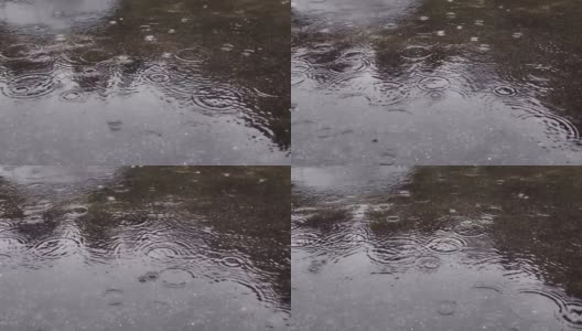 雨水落在柏油路上的大水坑里，淹没了道路。雨季的雨水落在混凝土地板上。高清在线视频素材下载