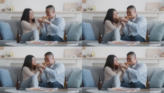 亚洲夫妇吃披萨，在家喂对方高清在线视频素材下载
