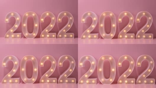 2022年新年创意设计概念编号来自粉色背景的黄色灯泡高清在线视频素材下载