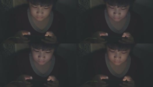 一个男孩在暗室里玩游戏高清在线视频素材下载