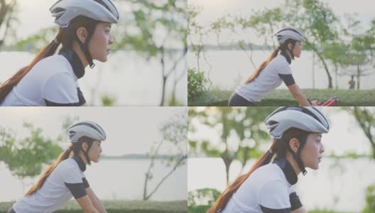 亚洲年轻美女晚上在公园里骑车健身。运动员健美和坚定的女孩在运动服锻炼自行车运动为她的健康健康。高清在线视频素材下载