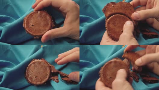 男人的手把糖饼干掰成一个圆圈的形状。高清在线视频素材下载