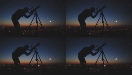 一个男人用天文望远镜观察星空的剪影。高清在线视频素材下载